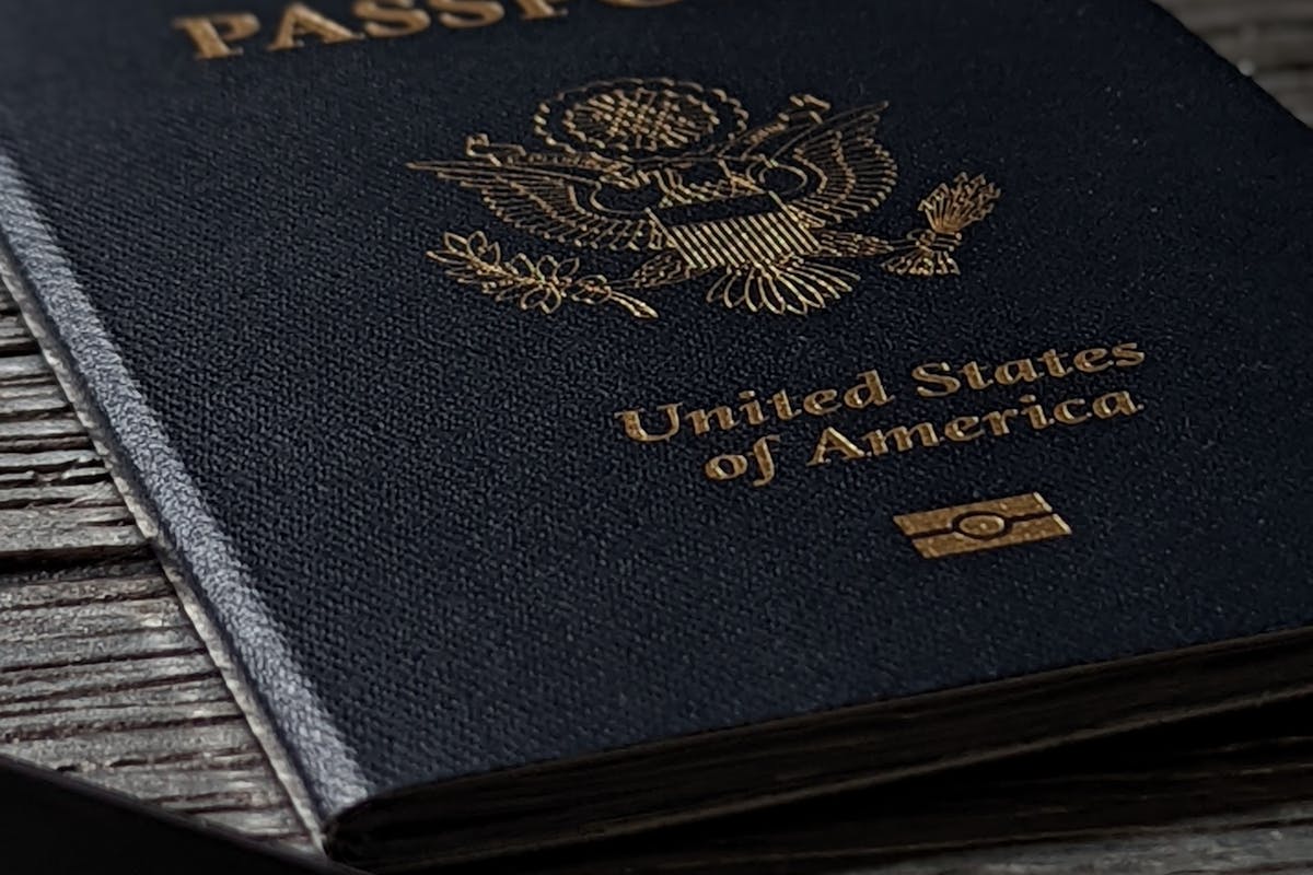 Aposentadoria de Estrangeiro no Brasil: Direitos no INSS 2 Passaporte sobre mesa de madeira, parte da documentação do imigrante (CRNM, CPF, comprovante de residência) para dar entrada na aposentadoria pelo INSS